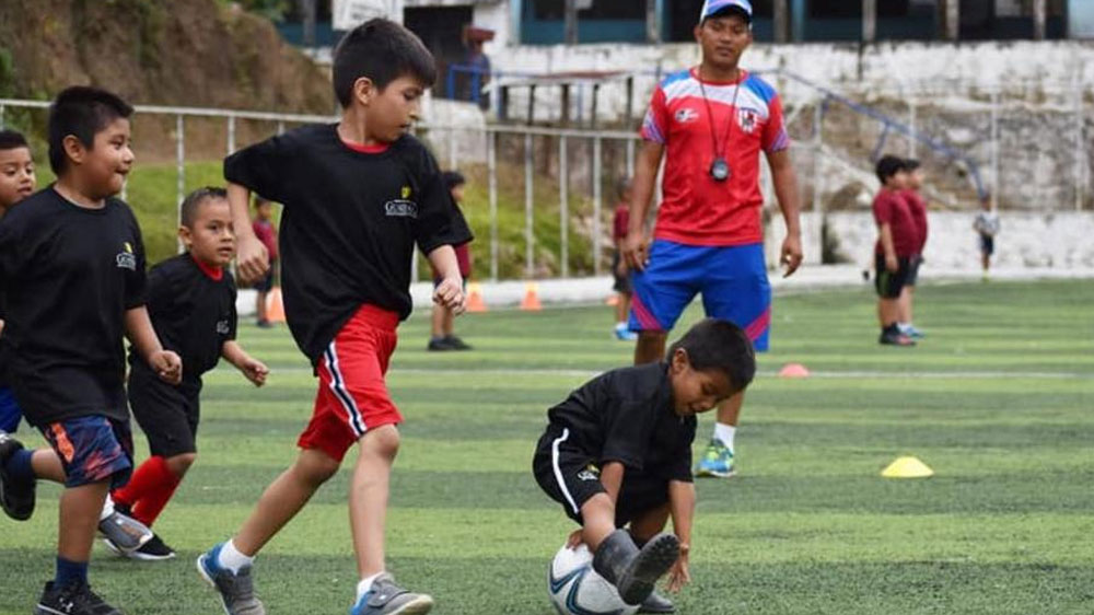 La historia del niño que juega fútbol con botas de hule