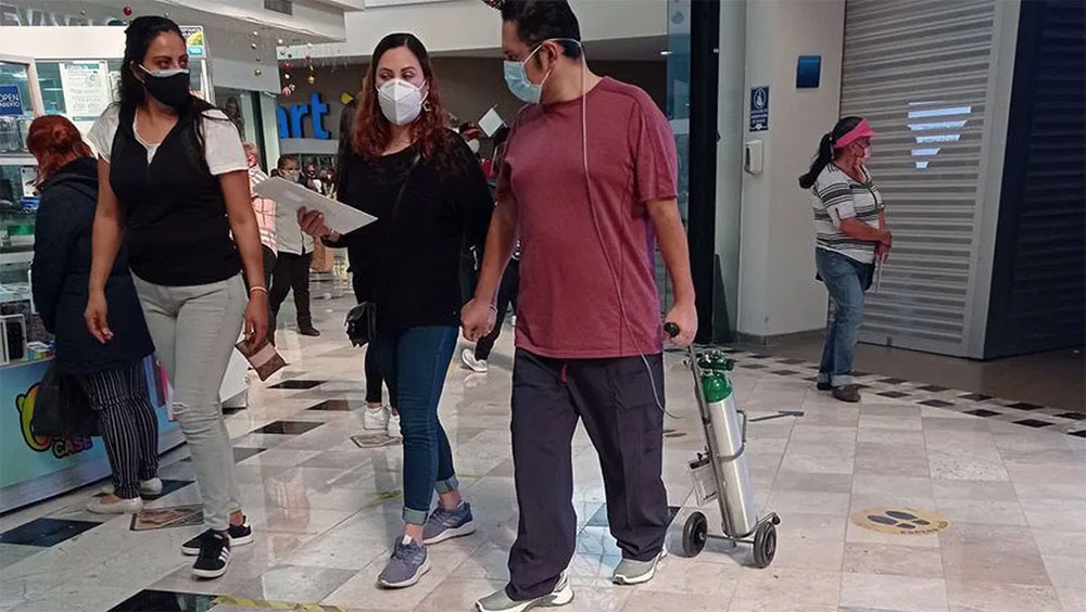 COVID-19: Hombre con tanque de oxígeno pasea un centro comercial