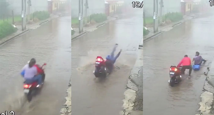 Mujer sale volando al caer la motocicleta en un agujero que ocultaba la lluvia (Video)