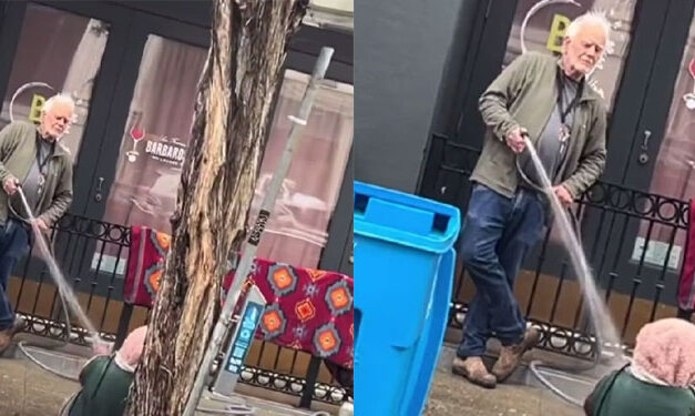 Hombre le tira agua con manguera a indigente que dormía frente a su negocio (Video)