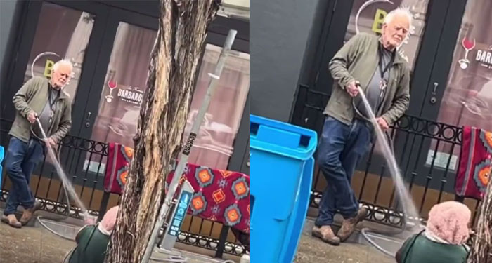 Hombre le tira agua con manguera a indigente que dormía frente a su negocio (Video)